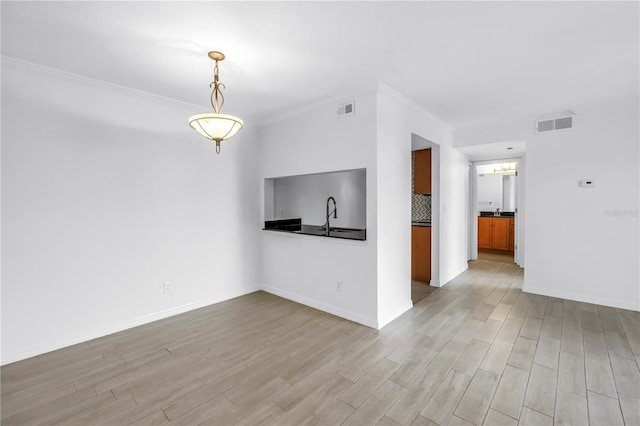 3300 Haviland Ct Unit 103, Palm Harbor, FL 34684 - unfurnished living room with light wood-style floors and crown molding