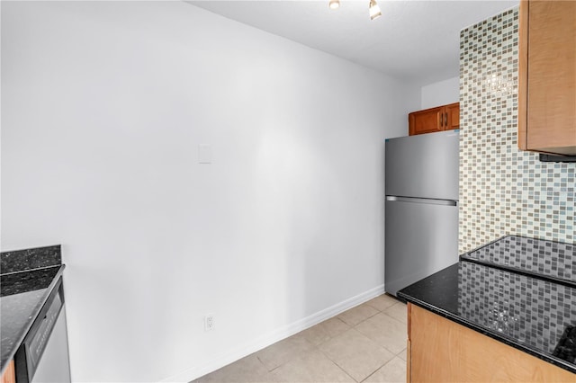 3300 Haviland Ct Unit 103, Palm Harbor, FL 34684 - kitchen with freestanding refrigerator, light tile patterned floors, and dark stone countertops