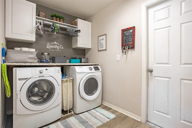 2053 Charleston Ln, Bartow, FL 33830 - laundry area featuring washing machine and dryer, light wood-type flooring, baseboards, and cabinet space