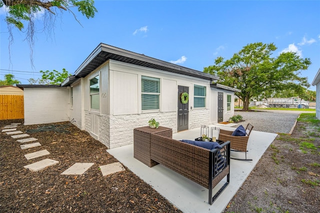 4626 8th Ave S, Saint Petersburg, FL 33711 - back of house featuring stone siding, a patio, and an outdoor living space