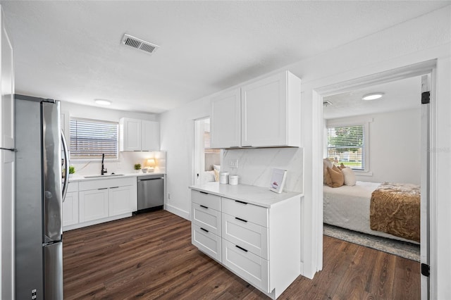 4626 8th Ave S, Saint Petersburg, FL 33711 - kitchen with appliances with stainless steel finishes, a sink, dark wood-type flooring, white cabinets, and light countertops