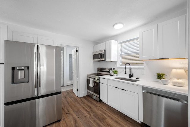 4626 8th Ave S, Saint Petersburg, FL 33711 - kitchen featuring appliances with stainless steel finishes, a sink, dark wood-type flooring, and white cabinetry