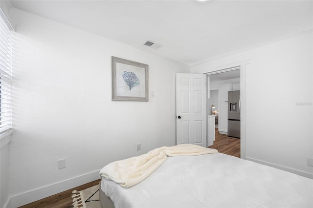 4626 8th Ave S, Saint Petersburg, FL 33711 - bedroom featuring stainless steel fridge with ice dispenser, dark wood-style floors, and baseboards