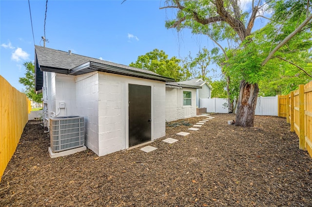 4626 8th Ave S, Saint Petersburg, FL 33711 - rear view of property featuring central AC, concrete block siding, roof with shingles, and a fenced backyard