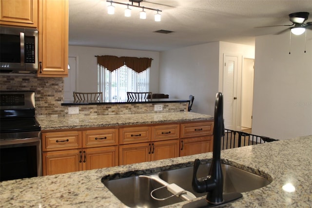 9705 45th Way N, Pinellas Park, FL 33782 - kitchen with electric range, decorative backsplash, a sink, ceiling fan, and light stone counters