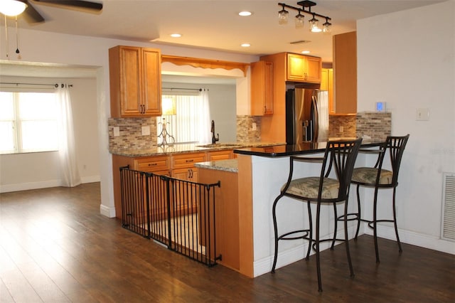 9705 45th Way N, Pinellas Park, FL 33782 - kitchen featuring stainless steel fridge, a sink, a peninsula, tasteful backsplash, and dark wood-type flooring