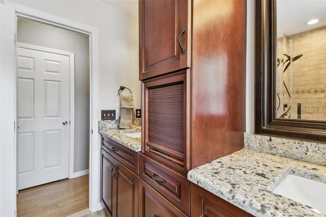 3673 Fremantle Dr, Palm Harbor, FL 34684 - bathroom featuring vanity, wood finished floors, a tile shower, and recessed lighting