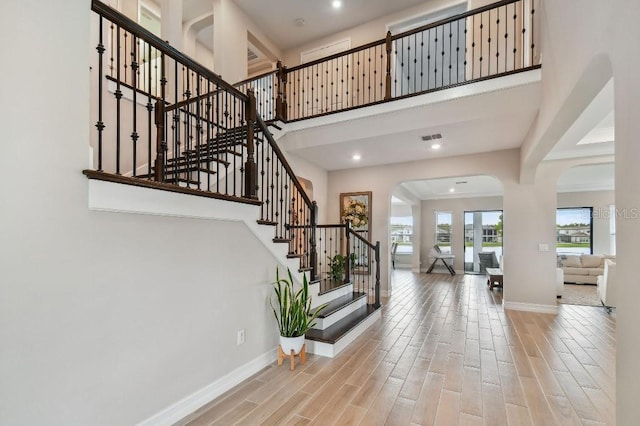 6129 Marsh Trail Dr, Odessa, FL 33556 - entrance foyer with arched walkways, baseboards, wood finished floors, stairs, and a high ceiling