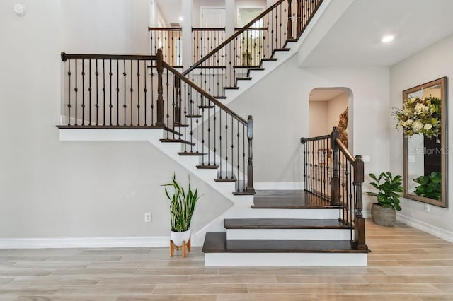 6129 Marsh Trail Dr, Odessa, FL 33556 - stairway with arched walkways, baseboards, wood finished floors, and recessed lighting