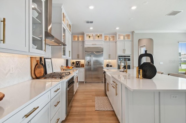 6129 Marsh Trail Dr, Odessa, FL 33556 - kitchen featuring stainless steel appliances, wall chimney exhaust hood, light wood finished floors, decorative backsplash, and recessed lighting