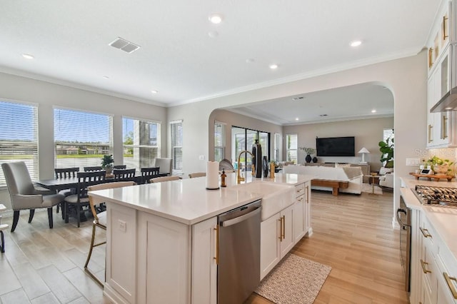 6129 Marsh Trail Dr, Odessa, FL 33556 - kitchen with appliances with stainless steel finishes, arched walkways, a sink, white cabinets, and recessed lighting