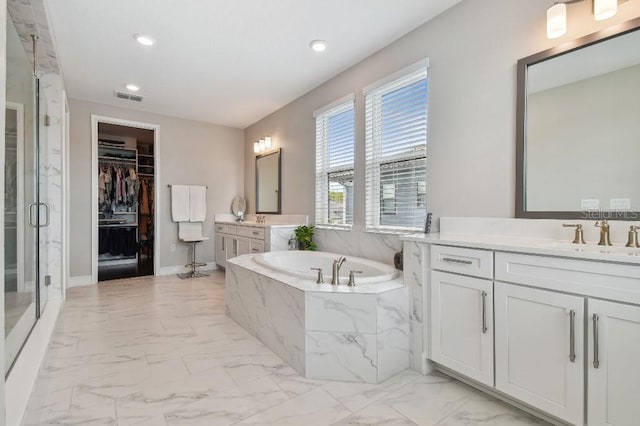 6129 Marsh Trail Dr, Odessa, FL 33556 - bathroom with marble look tile flooring, a garden tub, two vanities, a marble finish shower, and recessed lighting