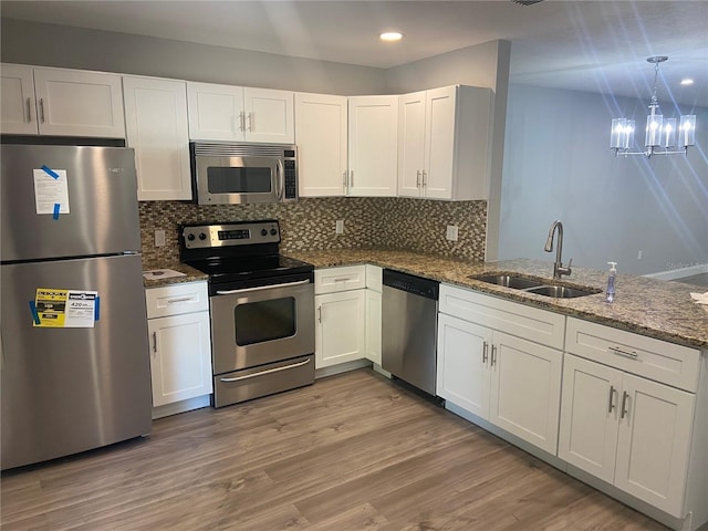 2160 Corbin Pl Unit C, Palm Harbor, FL 34683 - kitchen with appliances with stainless steel finishes, white cabinets, dark stone countertops, a chandelier, and recessed lighting