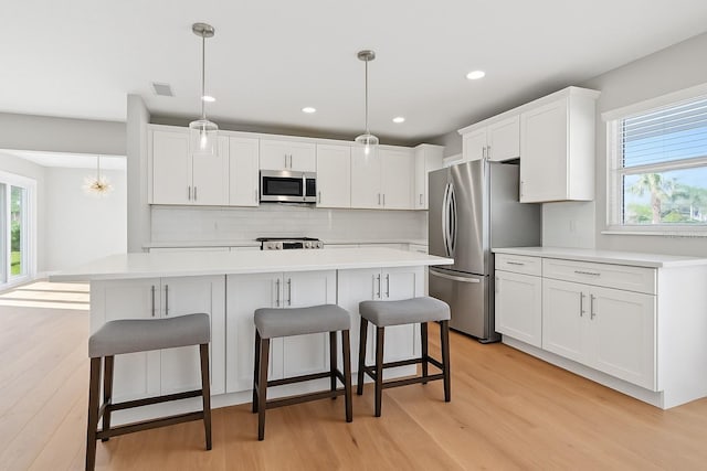1720 Bayou Grande Blvd NE, Saint Petersburg, FL 33703 - kitchen with stainless steel appliances, light wood-type flooring, light countertops, decorative backsplash, and recessed lighting