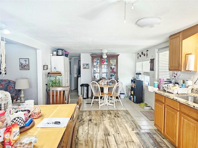 4352 Joy Dr, Land O Lakes, FL 34638 - kitchen featuring a textured ceiling, ceiling fan, and brown cabinets