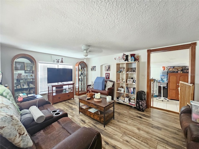 4352 Joy Dr, Land O Lakes, FL 34638 - living area featuring arched walkways, wood finished floors, and a textured ceiling