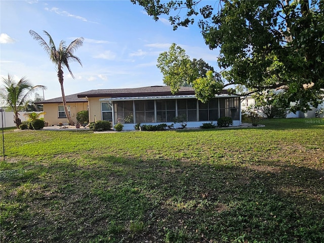1510 Flamingo Ln, Sun City Center, FL 33573 - back of house featuring a sunroom, a yard, and stucco siding