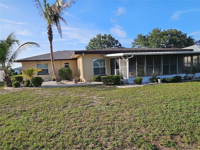 1510 Flamingo Ln, Sun City Center, FL 33573 - ranch-style home with a sunroom, stucco siding, and a front lawn