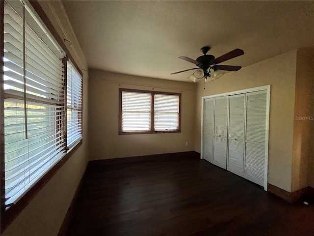 9907 Maggie St, Gibsonton, FL 33534 - unfurnished bedroom with dark wood-style floors, a closet, baseboards, and a ceiling fan