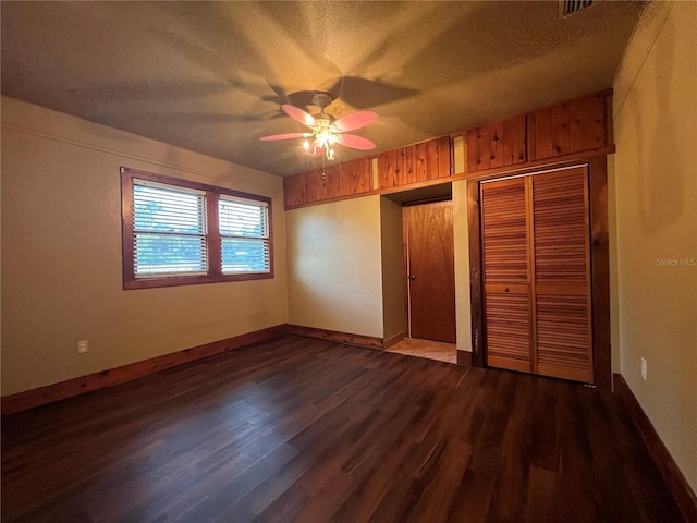 9907 Maggie St, Gibsonton, FL 33534 - unfurnished bedroom featuring a textured ceiling, dark wood-type flooring, baseboards, a closet, and a ceiling fan