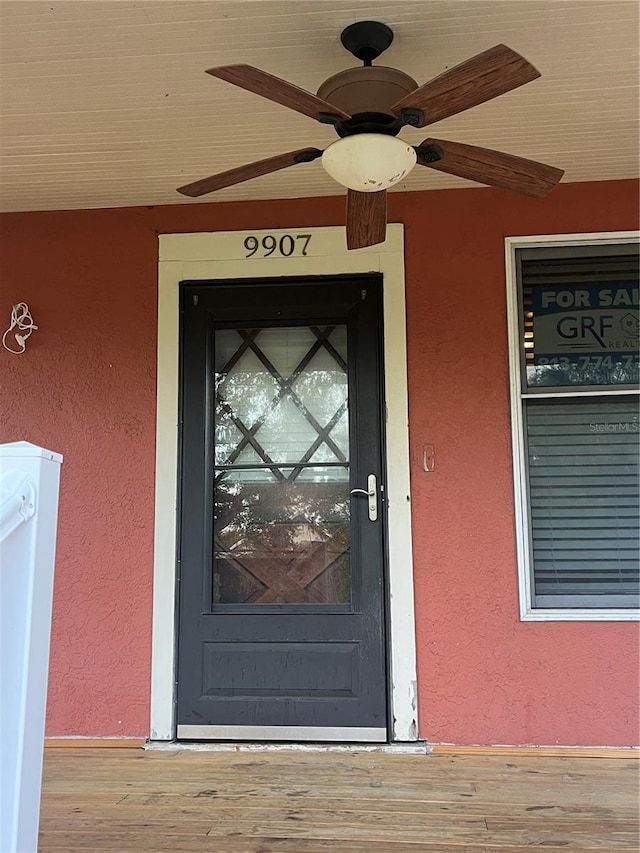 9907 Maggie St, Gibsonton, FL 33534 - view of exterior entry with stucco siding and ceiling fan