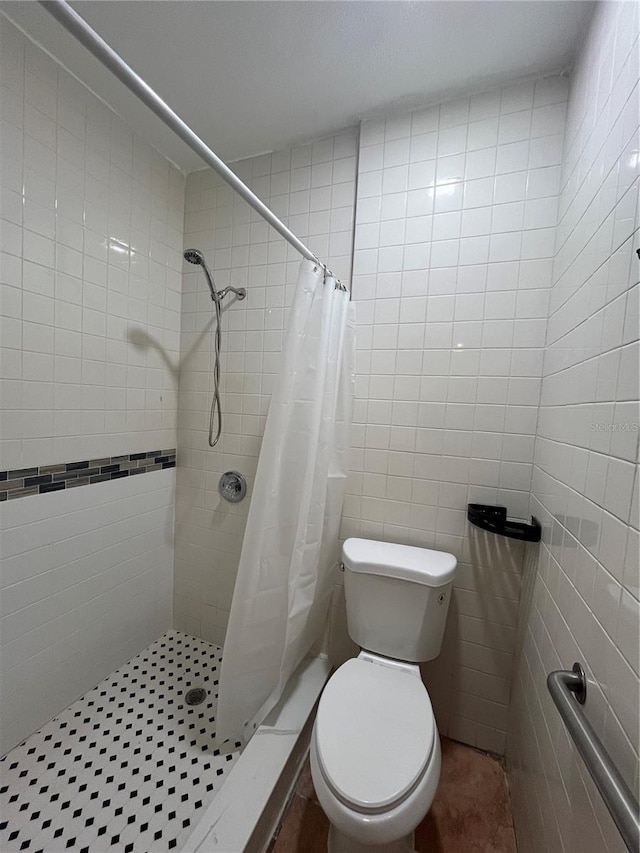 9907 Maggie St, Gibsonton, FL 33534 - bathroom featuring toilet, a shower stall, and tile walls