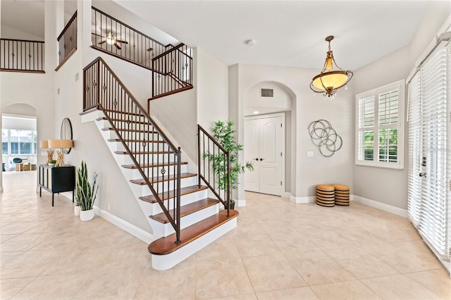 4306 Barracuda Dr, Bradenton, FL 34208 - tiled foyer featuring arched walkways, healthy amount of natural light, baseboards, stairs, and a towering ceiling