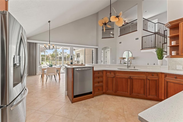 4306 Barracuda Dr, Bradenton, FL 34208 - kitchen featuring stainless steel appliances, a sink, a chandelier, brown cabinets, and a peninsula