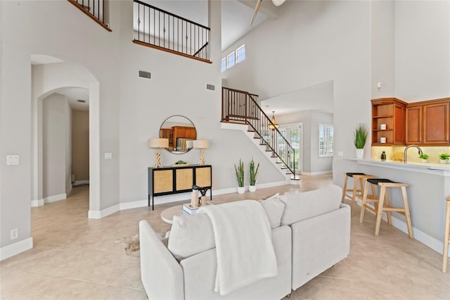 4306 Barracuda Dr, Bradenton, FL 34208 - living room featuring a high ceiling, arched walkways, plenty of natural light, stairway, and light tile patterned floors