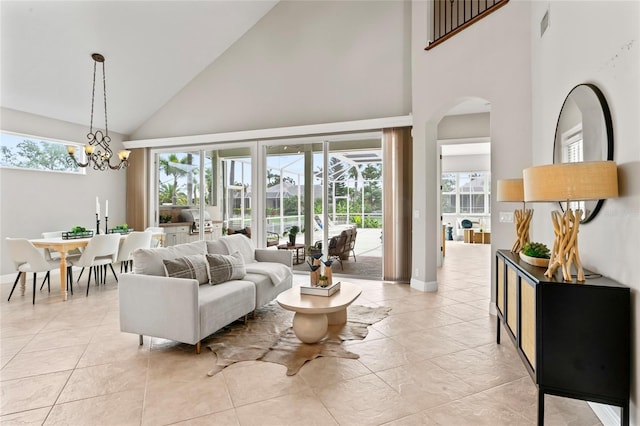 4306 Barracuda Dr, Bradenton, FL 34208 - living room with high vaulted ceiling, arched walkways, light tile patterned floors, a chandelier, and baseboards