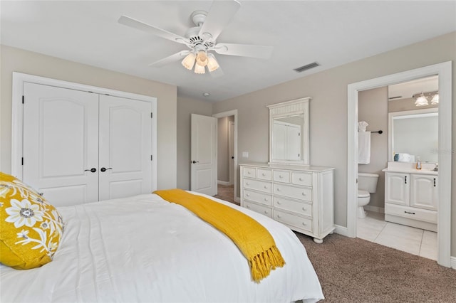 4306 Barracuda Dr, Bradenton, FL 34208 - bedroom with light carpet, a closet, baseboards, ensuite bath, and ceiling fan