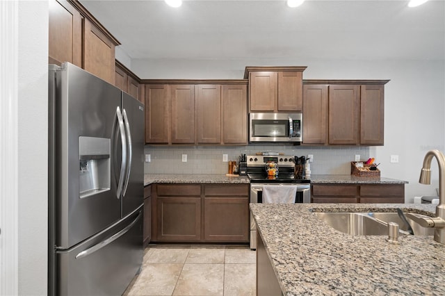 4504 Silver Lining St, Sarasota, FL 34238 - kitchen with appliances with stainless steel finishes, a sink, tasteful backsplash, light stone countertops, and recessed lighting