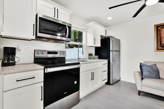 801 Kirkcaldy Way, Valrico, FL 33594 - kitchen featuring stainless steel appliances, a sink, ceiling fan, white cabinets, and light wood-style floors