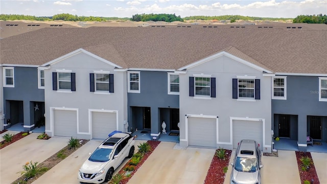 32977 Kaloko Rd, Wesley Chapel, FL 33543 - townhome / multi-family property featuring a garage, driveway, and stucco siding