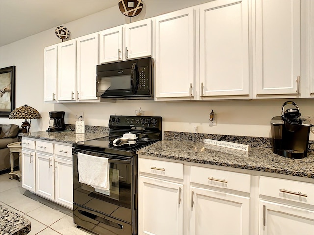 32977 Kaloko Rd, Wesley Chapel, FL 33543 - kitchen with black appliances, white cabinetry, dark stone countertops, and light tile patterned floors