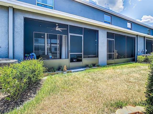 32977 Kaloko Rd, Wesley Chapel, FL 33543 - rear view of house with a sunroom, stucco siding, and a lawn