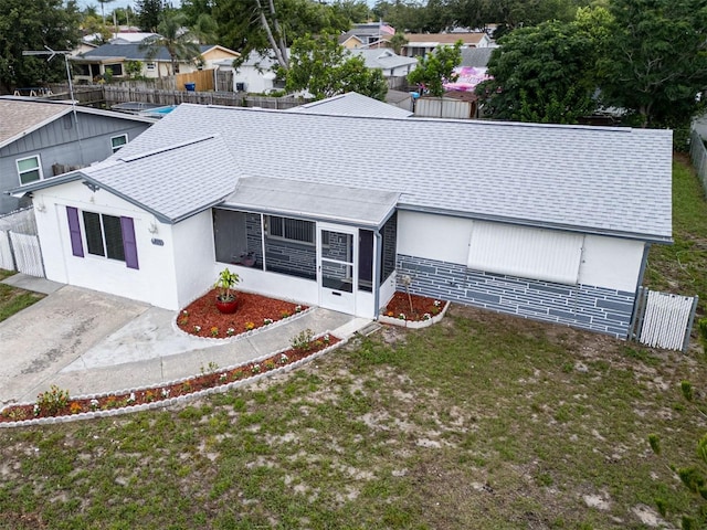 1415 Yale Dr, Holiday, FL 34691 - view of front of home with a shingled roof, a sunroom, and stucco siding