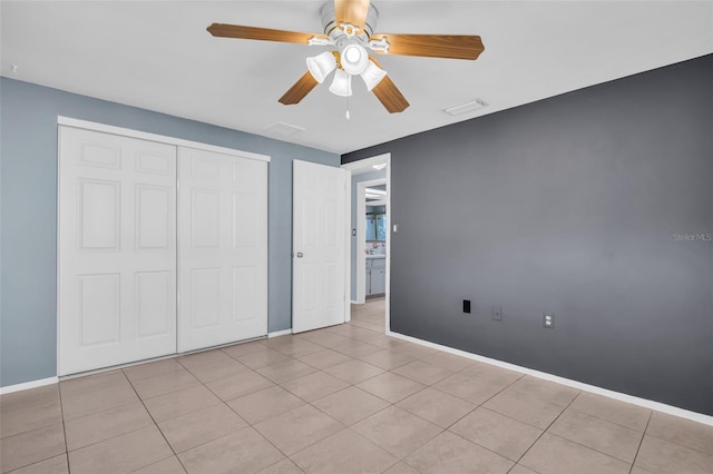 1415 Yale Dr, Holiday, FL 34691 - unfurnished bedroom with baseboards, a closet, tile patterned floors, and ceiling fan