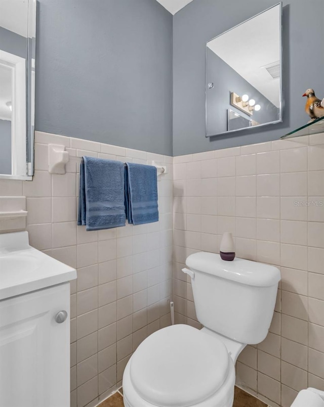 1415 Yale Dr, Holiday, FL 34691 - half bathroom featuring tile walls, vanity, and a wainscoted wall