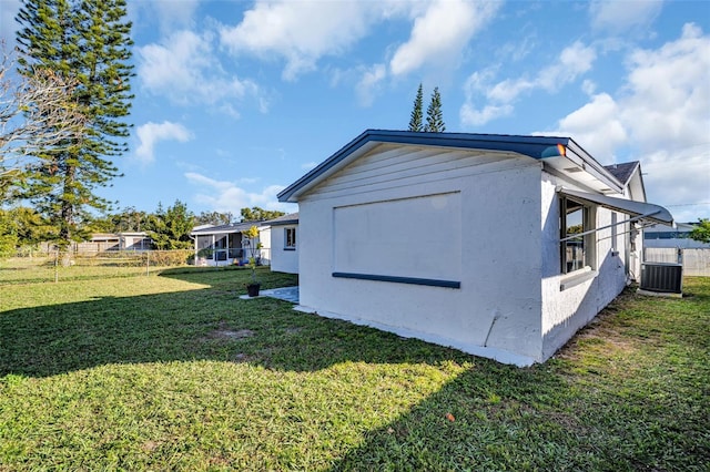 1415 Yale Dr, Holiday, FL 34691 - view of side of home with a central air condition unit and stucco siding