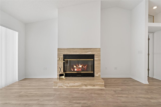 11411 Terrell, Spring Hill, FL 34606 - unfurnished living room featuring a glass covered fireplace, wood finished floors, baseboards, vaulted ceiling, and recessed lighting