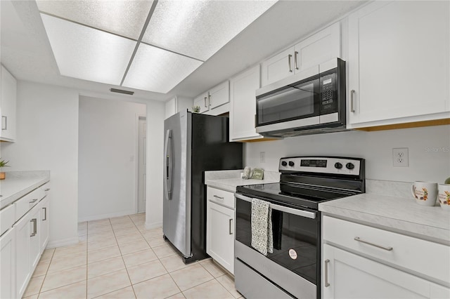 11411 Terrell, Spring Hill, FL 34606 - kitchen featuring stainless steel appliances, light countertops, white cabinets, light tile patterned floors, and baseboards