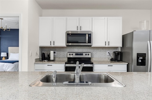 33668 Elm Hill Br, Wesley Chapel, FL 33545 - kitchen featuring stainless steel appliances, white cabinetry, and decorative backsplash