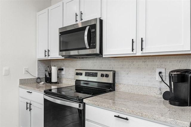 33668 Elm Hill Br, Wesley Chapel, FL 33545 - kitchen with appliances with stainless steel finishes, white cabinetry, tasteful backsplash, and light stone counters