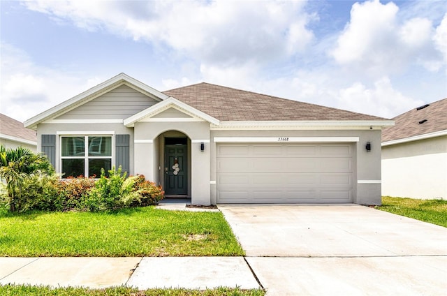 33668 Elm Hill Br, Wesley Chapel, FL 33545 - view of front of home with an attached garage, driveway, a front lawn, and stucco siding