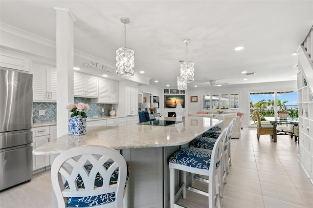 433 S Paula Dr Unit 31, Dunedin, FL 34698 - kitchen with freestanding refrigerator, recessed lighting, black electric stovetop, white cabinetry, and decorative backsplash