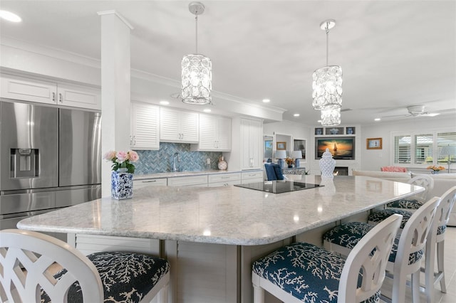 433 S Paula Dr Unit 31, Dunedin, FL 34698 - kitchen with black electric stovetop, open floor plan, a large island, decorative backsplash, and stainless steel fridge with ice dispenser