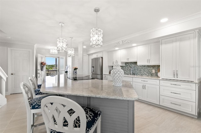 433 S Paula Dr Unit 31, Dunedin, FL 34698 - kitchen with stainless steel refrigerator with ice dispenser, a chandelier, ornamental molding, a kitchen bar, and white cabinets