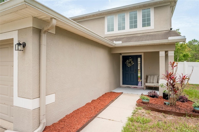 12624 White Bluff Rd, Hudson, FL 34669 - view of exterior entry featuring stucco siding, a porch, and a garage