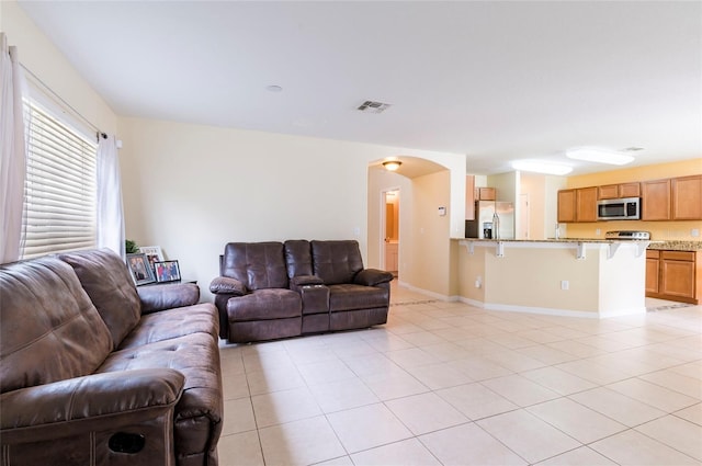 12624 White Bluff Rd, Hudson, FL 34669 - living area featuring light tile patterned floors, arched walkways, and baseboards